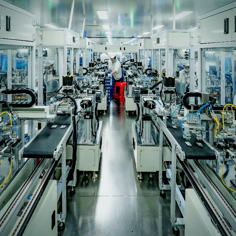 Automated battery assembly line with conveyor stations and operators